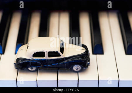 Dinky Austin Somerset black and white toy car drives tunefully along the piano keys Stock Photo