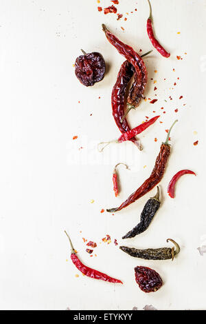 Assortment of dryed red hot chili peppers over white wooden background Stock Photo