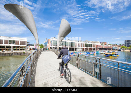 Cyclist crossing Pero's Bridge over St Augustine's Reach Bristol Harbour Bristol Avon England UK GB EU Europe Stock Photo