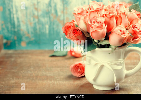 Pink roses in a pot on blue background Stock Photo