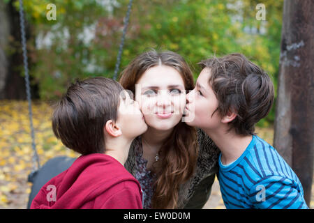 two boys kissing a teenage girl on her cheeks Stock Photo