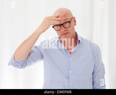 portrait of a bald-headed man with a headache Stock Photo