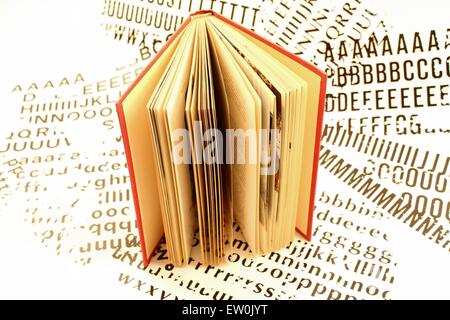 A book placed over a sheet, white, with printed letters. Stock Photo