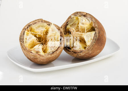 Opened cupuacu pod in a white plate on white background Stock Photo