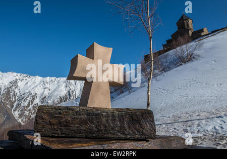 Small stone cross next to Holy Trinity Church (Tsminda Sameba) from 14th century near Gergeti village, Georgia Stock Photo