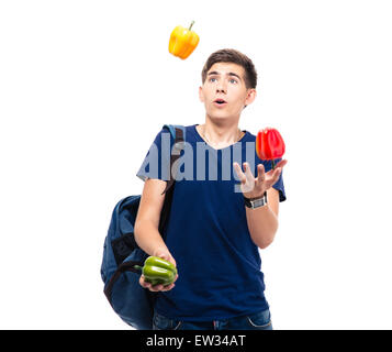 Casual young man juggles with pepper isolated on a white background Stock Photo