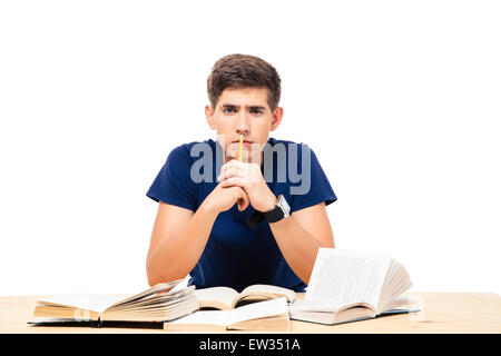 Male student sitting at the table with books isolated on a white background Stock Photo