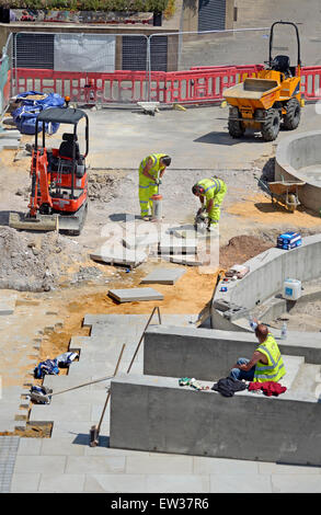 London, England, UK. Workers cutting concrete slabs for paving, by the Millennium Bridge Stock Photo