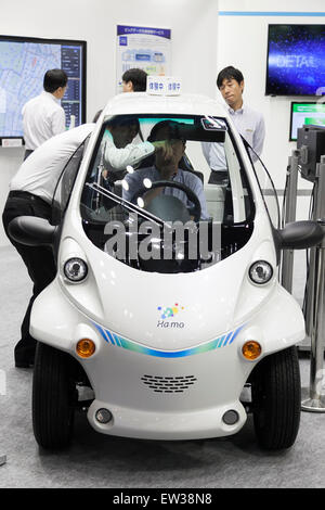 Tokyo, Japan. 17th June, 2015. An exhibitor shows to visitor an electric vehicle of Toyota ''Ha:mo'' at the Smart Community Japan 2015 in exhibition in Tokyo, Big Sight on June 17, 2015, Tokyo, Japan. The exhibition promotes both domestic and overseas next-generation technologies. The last year 39,879 visitors attend the expo during three days. This year 233 enterprises and organizations will show their products from June 17th to 19th. Credit:  Rodrigo Reyes Marin/AFLO/Alamy Live News Stock Photo