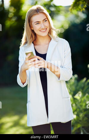 Girl reading message on her iPhone Stock Photo