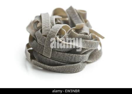 black tagliatelle pasta on white background Stock Photo