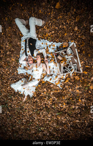 wedding couple lying under a tree Stock Photo
