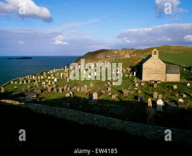 Looking eastwards from the coastal path to Llanbadrig church and Ynys Badrig in late afternoon light. Stock Photo