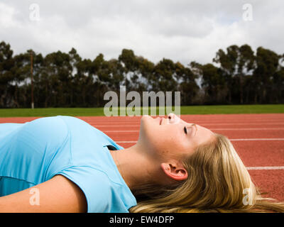 Blond woman laying on a track San Diego California. Stock Photo