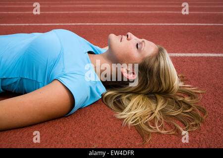 Blond woman laying on a track San Diego California. Stock Photo
