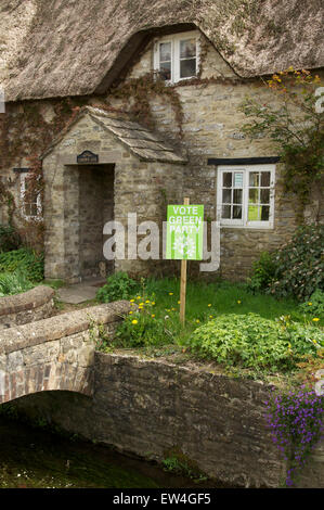 Vote green party. A political placard in a rural cottage garden supports the Green Party in the 2015 UK general election. Dorset, England, UK. Stock Photo