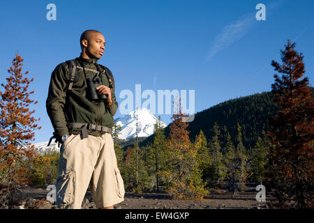 African American man Cupid Alexander stands in forest during hike near Mt. Hood in the Cascade Mountains Oregon. Stock Photo