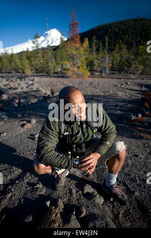 African American man Cupid Alexander rests while hiking  near Mt. Hood in the Cascade Mountains Oregon. Stock Photo