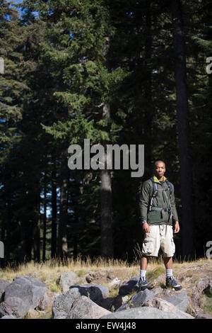 African American man Cupid Alexander stands in front of forest trees in the Cascade Mountains Oregon. Stock Photo