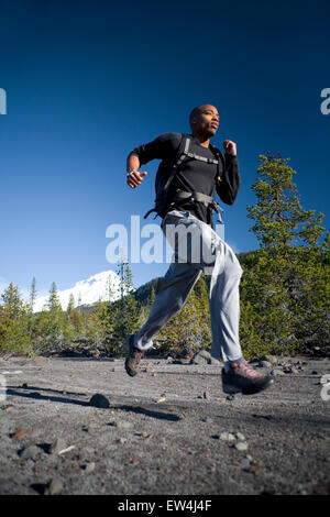 African American man Cupid Alexander runs on trail near Mt. Hood in the Cascade Mountains Oregon. Stock Photo