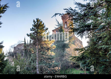 A medieval crenellated clock tower stands on a peak overlooking the ...