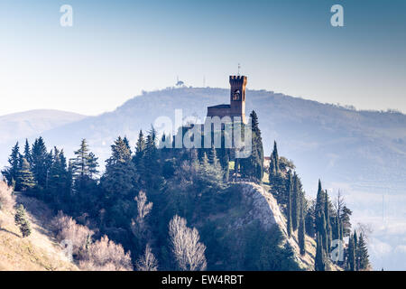 A medieval crenellated clock tower stands on a peak overlooking the ...