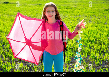Kid girl holding pink kite traditional in spring on meadow Stock Photo