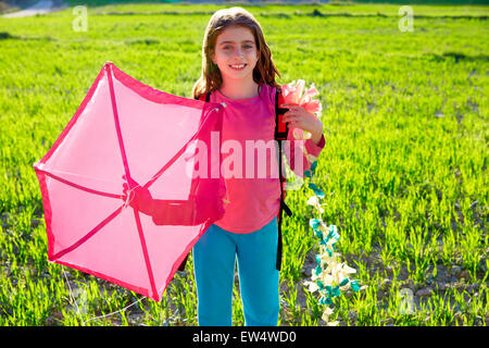 Kid girl holding pink kite traditional in spring on meadow Stock Photo