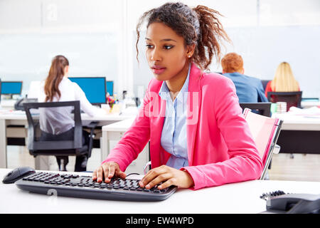 african young businesswoman working in office with computer Stock Photo