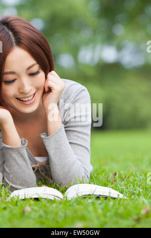 Young woman lying down on front and looking down with smile Stock Photo