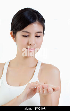 Young woman applying and looking down with smile Stock Photo