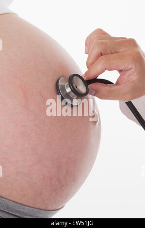 Close-up of stethoscope on pregnant woman's abdomen, Stock Photo
