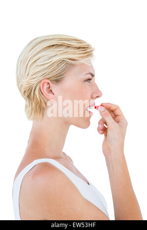 Pretty blonde woman ready to swallow red pill Stock Photo