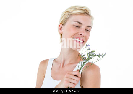 Gorgeous blonde woman smelling flowers Stock Photo