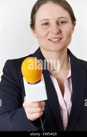 Studio Portrait Of Female Journalist With Microphone Stock Photo