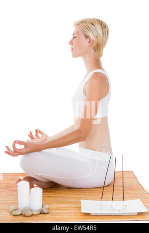 Fit woman meditating on bamboo mat Stock Photo