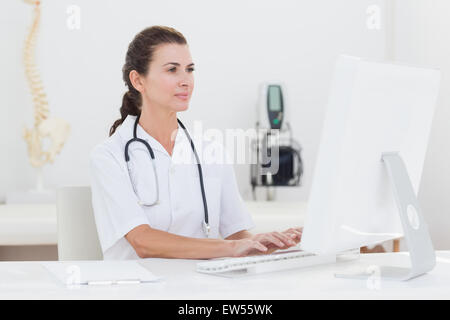 Concentrated female doctor using computer Stock Photo