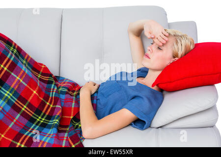 Attractive blonde woman having headache on the couch Stock Photo
