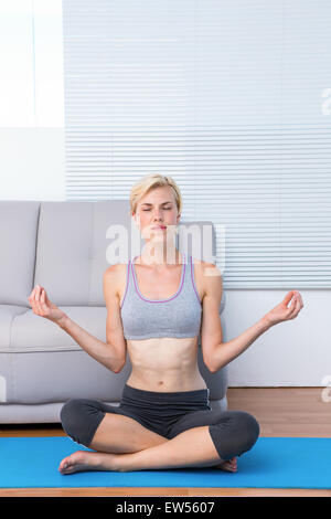 Fit blonde woman meditating Stock Photo