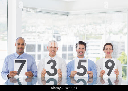 Smiling business team showing paper with rating Stock Photo