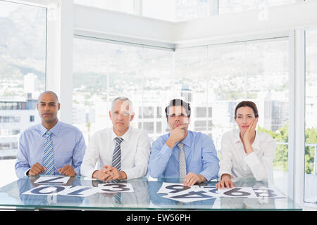Concentrated business team sitting with their vote on the desk Stock Photo