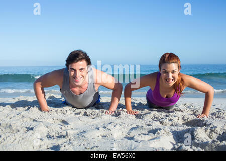 Happy couple doing push ups together Stock Photo