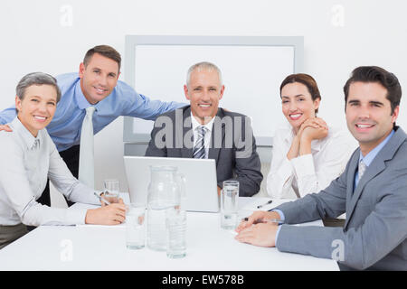 Business team working happily together on laptop Stock Photo