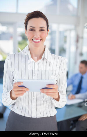 Businesswoman holding tablet and looking at camera Stock Photo