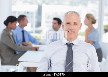Smiling businessman and his team Stock Photo