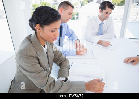 Business team writing brainstorming ideas in their notepad Stock Photo
