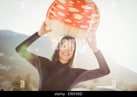 woman in wetsuit with a surfboard on a sunny day Stock Photo
