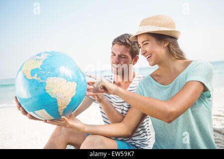 Happy couple looking at globe planet Stock Photo