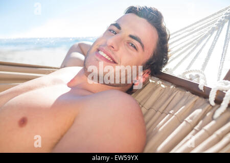 Handsome man relaxing in the hammock and smiling at camera Stock Photo