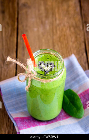 Green vegetable and herbs smoothie with heart of poppy and sesame seeds. Love for a healthy raw food concept. Stock Photo